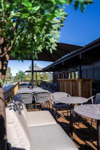 a row of tables with chairs and umbrellas at Honne Hotell in Biri