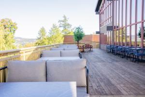 a row of tables and chairs on a balcony at Honne Hotell in Biri