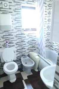 a bathroom with a toilet and a tub and a sink at Galleywood House in Great Baddow +3 photos