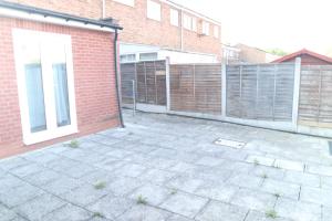 a patio with a fence and a brick building at Galleywood House in Great Baddow