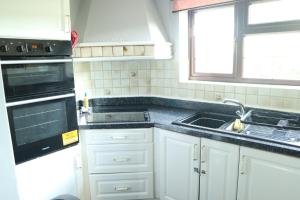 a kitchen with a sink and a stove top oven at Galleywood House in Great Baddow
