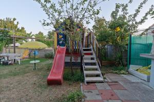 a playground with a slide in a yard at Apartments Vjeko in Nin