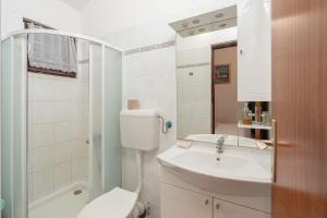 a white bathroom with a toilet and a sink at Apartments Vjeko in Nin +26 photos