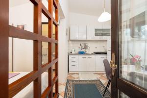 a kitchen with white cabinets and a table and a door at Apartments Vjeko in Nin