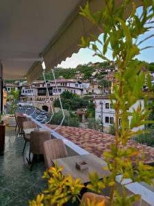 een balkon met tafels en stoelen en uitzicht op een stad bij Villa Mishel in Berat