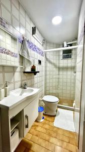 a bathroom with a sink and a toilet and a shower at Apartamento completo no Centro de Nova Friburgo in Nova Friburgo