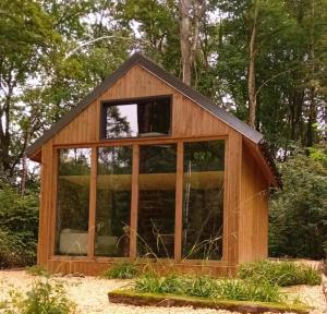 马尔什昂法梅讷La Cabane du Gardien的一座带大玻璃窗的小木房子