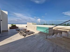 a balcony of a house with a swimming pool at Beatiful Loft in Puerto Morelos Beach Front 9-4 in Puerto Morelos