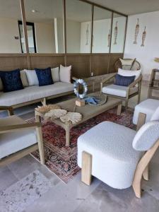 a living room with couches and chairs and a table at Beatiful Loft in Puerto Morelos Beach Front 9-4 in Puerto Morelos +54 photos
