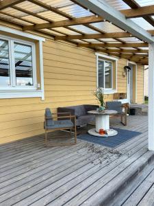 een patio met een tafel en stoelen op een houten terras bij Bocmano vila in Meteliai +17 foto's