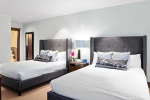 a bedroom with two beds and a chair at Ballard North 202 - Ballard Bluebird in Telluride