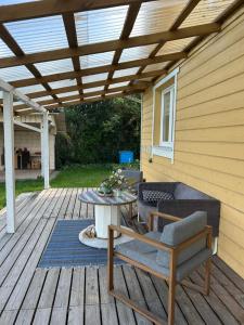 a patio with a table and chairs on a deck at Bocmano vila in Meteliai +4 photos