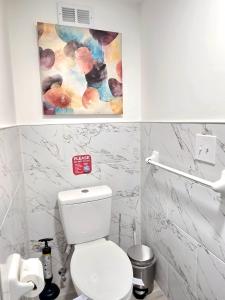 a bathroom with a toilet and a painting on the wall at Vessel Hotel Studio Suite of Atlanta in Atlanta +7 photos