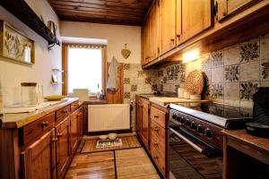 a kitchen with wooden cabinets and a stove at Casa Clara - Fronte piste da sci in Padola