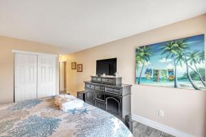 - une chambre avec un lit, une télévision et un tableau dans l'établissement Hilton Head Haven Coligny Beach 3 Balconies, à Île de Hilton-Head