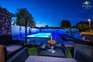 un patio trasero con piscina por la noche en Apartments & Villa Tisno, en Obrovac