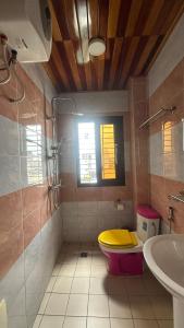a bathroom with a yellow toilet and a sink at Residence Le Sommet in Douala