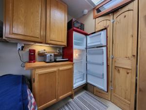 a small kitchen with an open refrigerator and wooden cabinets at Caravan Across The Street From The Beach in Blaine