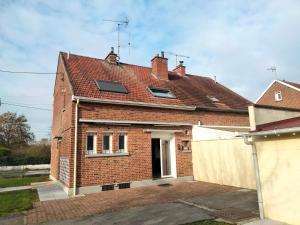 a brick house with windows and a white fence at Pretty Poppy in Albert