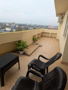 a balcony with two chairs and a view of a city at Ocean Park Haven Apartments in Kannur