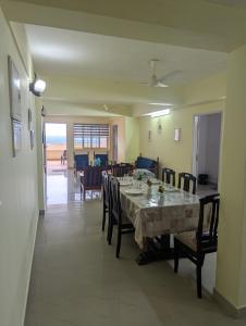 a dining room with a long table and chairs at Ocean Park Haven Apartments in Kannur