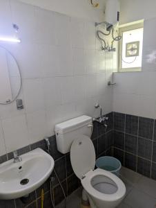 a bathroom with a toilet and a sink at Ocean Park Haven Apartments in Kannur