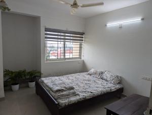 a bedroom with a bed in a room with a window at Ocean Park Haven Apartments in Kannur