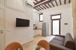 a living room with a couch and a tv on a wall at Suite n10 - Modern flat in historic center in Perugia