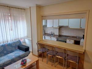 a living room with a couch and a kitchen at Ribadesella Centro, El trasiegu in Ribadesella