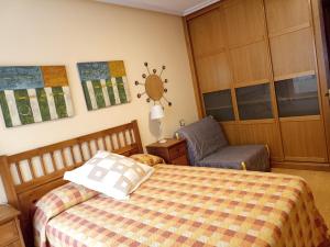 a bedroom with a bed and a chair at Ribadesella Centro, El trasiegu in Ribadesella