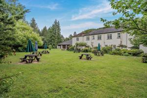 a group of picnic tables in the grass in front of a building at 3 Bed in Cwmtaf oc-p32979 in Merthyr Tydfil