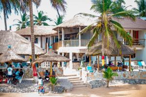 a resort on the beach with palm trees and people at Oasis beach resort in Cape Coast