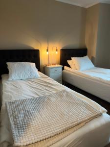 two beds sitting next to each other in a bedroom at SteneBo in Stenestad