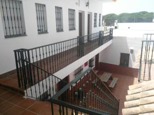 un escalier dans un bâtiment avec rampe noire dans l'établissement Parrilla Venta el Andaluz, à Conil de la Frontera