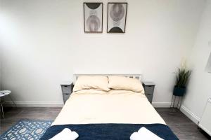 エッジウェアにあるStylish and Cozy flat in Londonの壁に2枚の写真が飾られたベッドルームのベッド1台