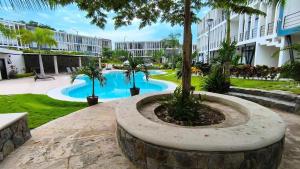 a courtyard with a pool with palm trees and a building at "Modern Style in Mezcales: Minutes from the Beach" in Mezcales