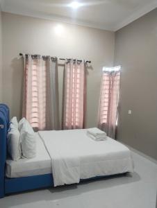 ein Schlafzimmer mit einem Bett mit rosa Vorhängen und weißen Laken in der Unterkunft Homestay Salsabila Langkawi in Kampung Padang Masirat + 18 Fotos