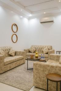 ein Wohnzimmer mit zwei Sofas und einem Tisch in der Unterkunft شقق جنان المخدومة Jenaan Apartments in Najran