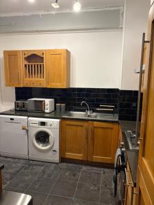 a kitchen with a sink and a washing machine at 3 Bed Luxury Contractors Apartment, Free Parking, City Centre, Fast WiFi by Opulent Stays in Derby