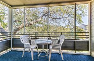 a table and two chairs on a screened porch with a window at Ocean Creek Resort in Myrtle Beach