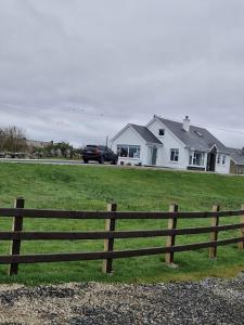 a car parked in a field next to a fence at MacRuairi House in Burtonport
