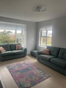 a living room with two couches and a rug at MacRuairi House in Burtonport
