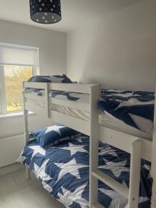 a bedroom with two bunk beds and a window at MacRuairi House in Burtonport