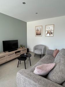 a living room with a couch and a flat screen tv at Vakantiewoning Laurijn in Bilzen
