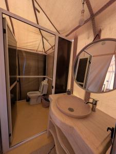 a bathroom with a sink and a mirror at Luxury Desert Camp Merzouga with Air Conditioning and Heating in Merdani