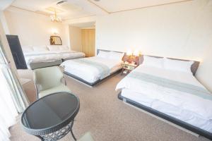 a hotel room with three beds and a chair at JUN RESORT HOTEL - Vacation STAY 03681v in Hasunuma