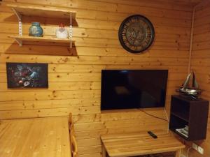 a living room with a television and a clock on the wall at chalet in Thueyts