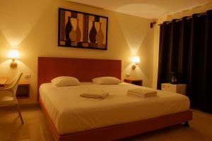 a bedroom with a bed with two towels on it at Guest house La Casa del Quetzal in Mérida