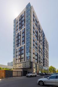un grand bâtiment avec des voitures garées dans un parking dans l'établissement Renest Oslo Cozy Escape, à Chişinău