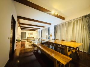 a dining room with a table and a couch at Ploythai Villa Koh Phangan in Haad Pleayleam